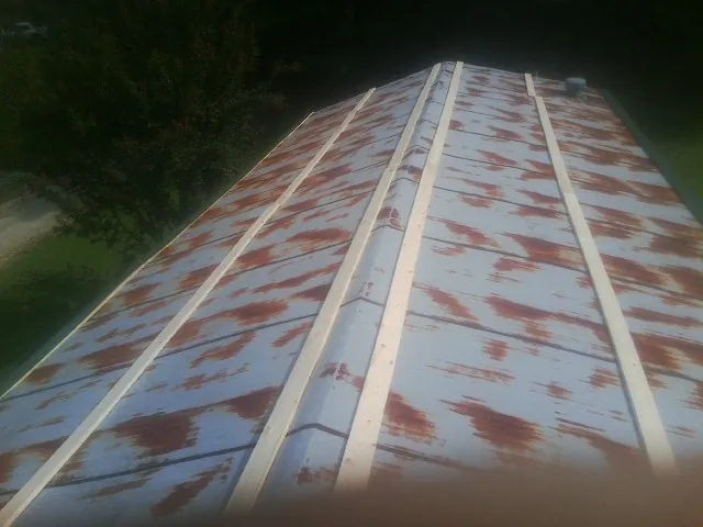 Rusted metal roof panels with new wood purlins before replacement — Storm Damage Roof Repair in Hartstown by Roofing Brothers